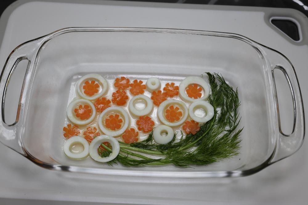 На дно глубокой формы выложите укроп, морковь и белки